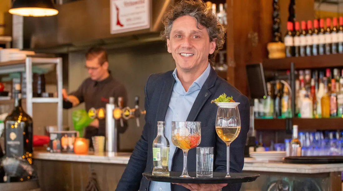 Gastheer van Bodega Manolitos in Assen aan de bar met wijn en cocktails