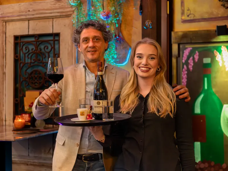 Mano en Layla met een dienblad wijn en koffie